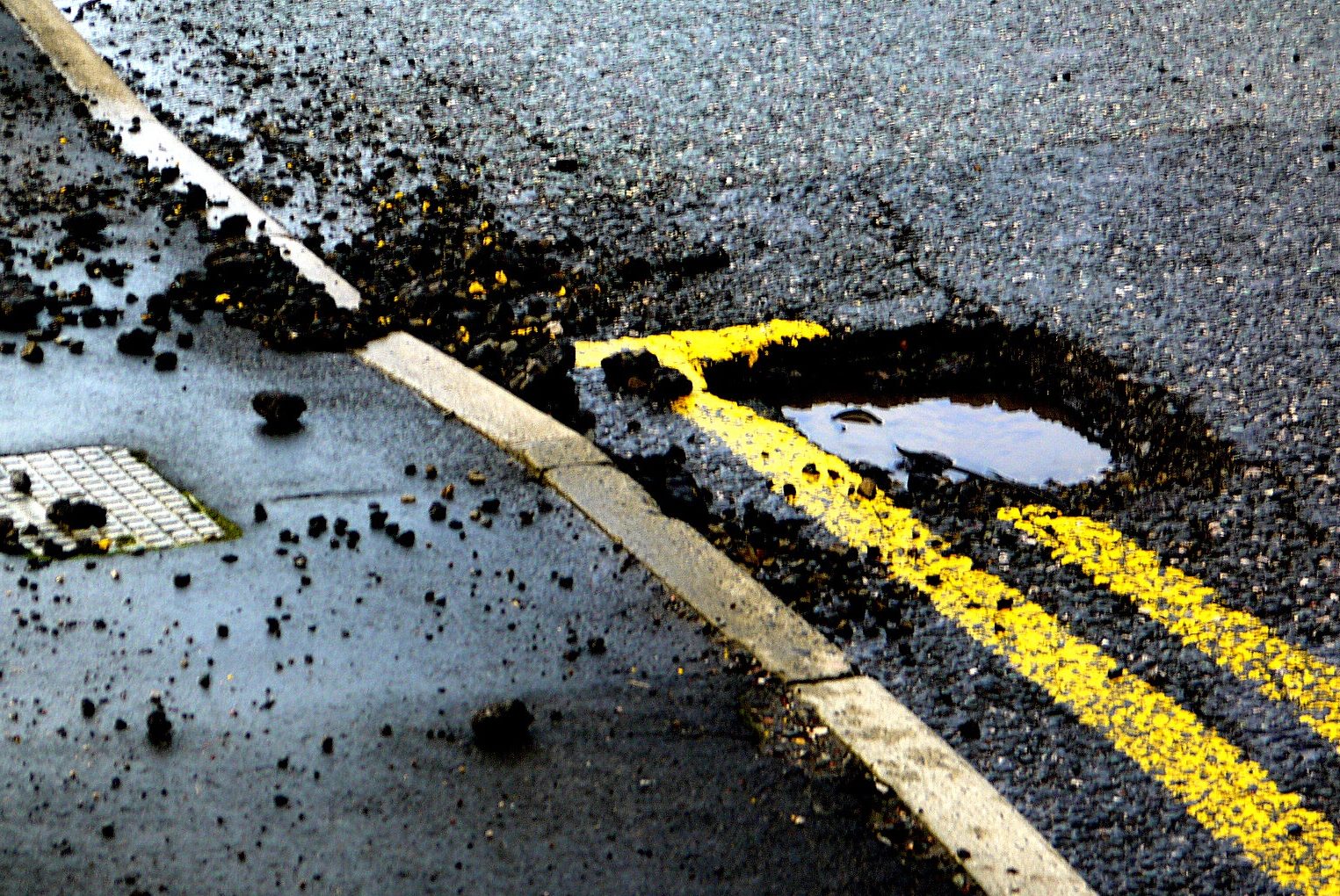 Road infrastructure problems in Pakistan shown by potholes and surface damage caused by poor drainage
