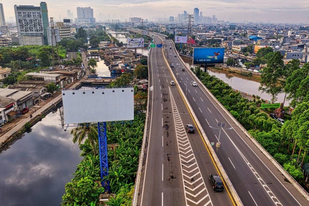 A wide-angle golden hour shot of a newly constructed, stable concrete highway flyover bridge built on strong engineered foundations in Pakistan.